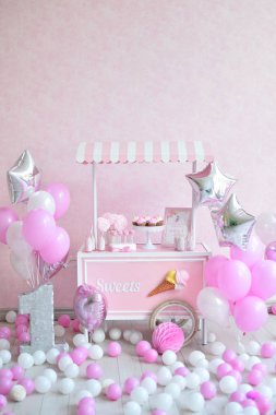 Dekorasyon doğum günü partisi için. Bir sürü kek. Bir sürü balonlar kırmızı ve beyaz renkler. Bir yıl Doğum günü süsleri. Balonlar pembe ve beyaz renkler. Dondurma partisi. 