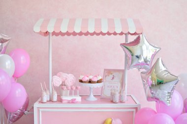 Dekorasyon doğum günü partisi için. Bir sürü kek. Bir sürü balonlar kırmızı ve beyaz renkler. Bir yıl Doğum günü süsleri. Balonlar pembe ve beyaz renkler. Dondurma partisi. 