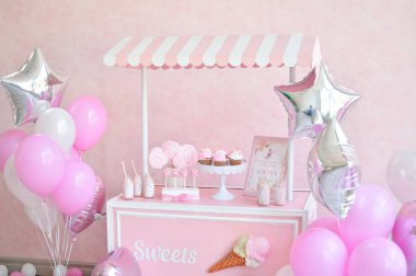 Dekorasyon doğum günü partisi için. Bir sürü kek. Bir sürü balonlar kırmızı ve beyaz renkler. Bir yıl Doğum günü süsleri. Balonlar pembe ve beyaz renkler. Dondurma partisi. 