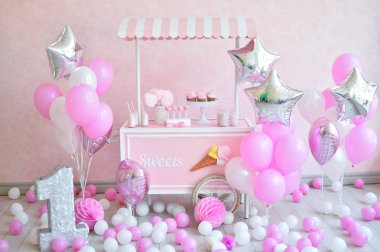 Dekorasyon doğum günü partisi için. Bir sürü kek. Bir sürü balonlar kırmızı ve beyaz renkler. Bir yıl Doğum günü süsleri. Balonlar pembe ve beyaz renkler. Dondurma partisi. 