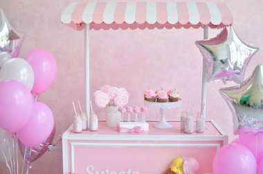 Dekorasyon doğum günü partisi için. Bir sürü kek. Bir sürü balonlar kırmızı ve beyaz renkler. Bir yıl Doğum günü süsleri. Balonlar pembe ve beyaz renkler. Dondurma partisi. 