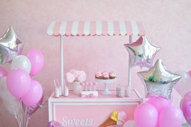 Dekorasyon doğum günü partisi için. Bir sürü kek. Bir sürü balonlar kırmızı ve beyaz renkler. Bir yıl Doğum günü süsleri. Balonlar pembe ve beyaz renkler. Dondurma partisi. 