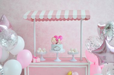 Dekorasyon doğum günü partisi için. Bir sürü kek. Bir sürü balonlar kırmızı ve beyaz renkler. Bir yıl Doğum günü süsleri. Balonlar pembe ve beyaz renkler. 