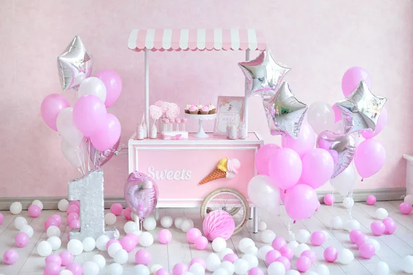 Decorations for birthday party. A lot of cakes. A lot of balloons red and white colors. One year birthday decorations. balloons pink and white colors. Ice cream party.