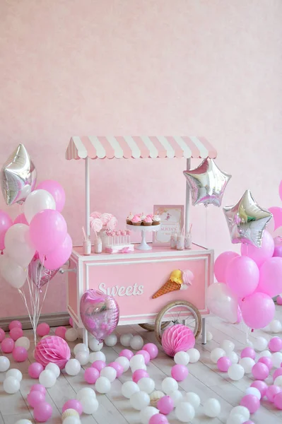 Dekorasyon doğum günü partisi için. Bir sürü kek. Bir sürü balonlar kırmızı ve beyaz renkler. Bir yıl Doğum günü süsleri. Balonlar pembe ve beyaz renkler. Dondurma partisi. 
