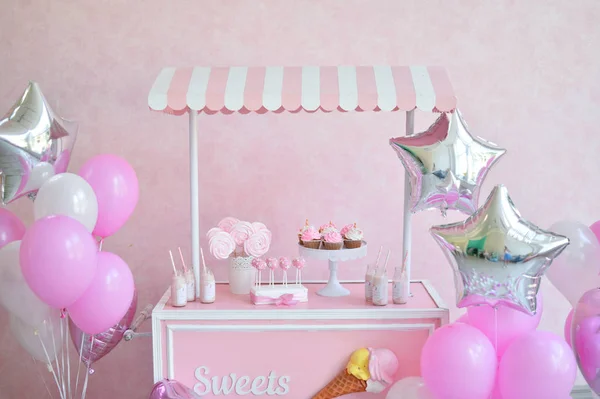 Decorations for birthday party. A lot of cakes. A lot of balloons red and  white colors. One year birthday decorations. balloons pink and white  colors. Ice cream party. - Stock Image - Everypixel