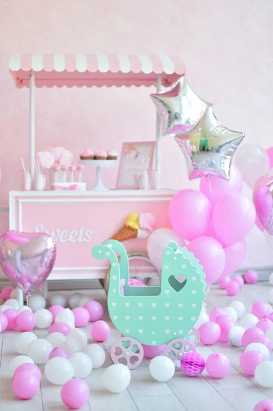 Decorations for birthday party. A lot of cakes. A lot of balloons red and white colors. One year birthday decorations. balloons pink and white colors. Ice cream party.