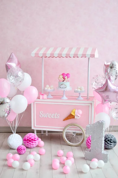 Dekorasyon doğum günü partisi için. Bir sürü kek. Bir sürü balonlar kırmızı ve beyaz renkler. Bir yıl Doğum günü süsleri. Balonlar pembe ve beyaz renkler. Dondurma partisi. 