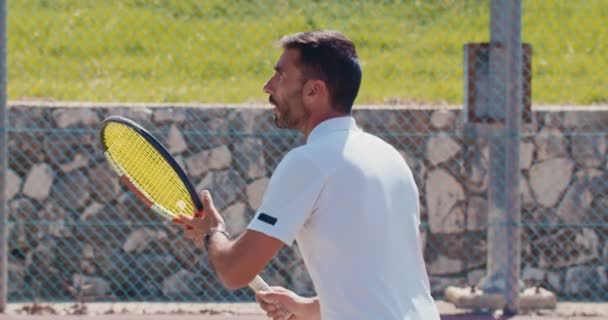 Movimiento lento de un jugador de tenis golpeando la pelota durante un partido de tenis — Vídeos de Stock