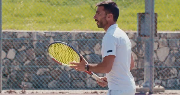 Αργή κίνηση από έναν παίκτη του τένις χτυπώντας τη μπάλα κατά τη διάρκεια ενός παιχνιδιού τένις — Αρχείο Βίντεο