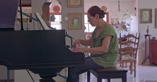 Старуха играет на рояле у себя дома — стоковое видео