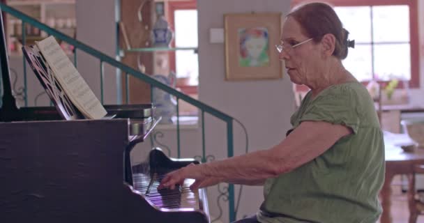 Vieja tocando un piano de cola en su casa — Vídeos de Stock