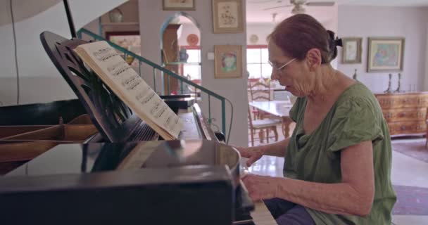 Vieja tocando un piano de cola en su casa — Vídeo de stock