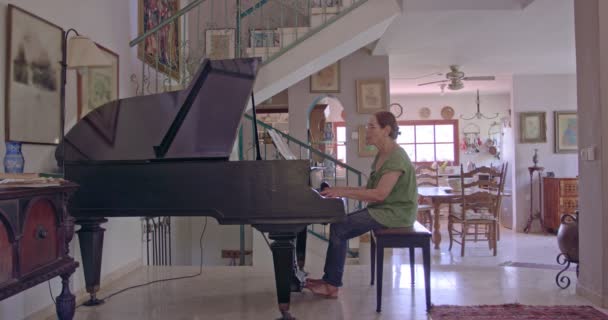 Oude vrouw een grand piano spelen bij haar huis — Stockvideo