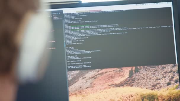 Programmerare som sitter framför en skärm kodning programvara — Stockvideo