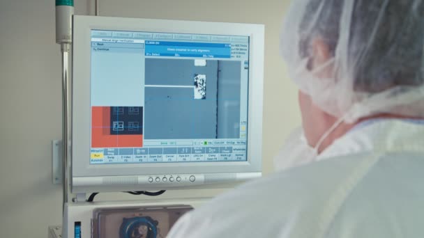 Trabajador frente a una pantalla de ordenador en una línea de fabricación electrónica — Vídeo de stock