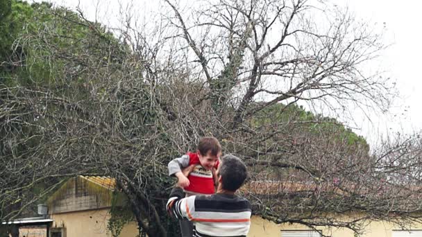 Movimiento lento de padre lanzando a su adorable hijo en el aire — Vídeos de Stock