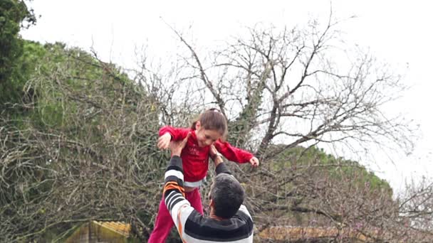 Mouvement lent du père jetant sa fille adorable dans les airs — Video