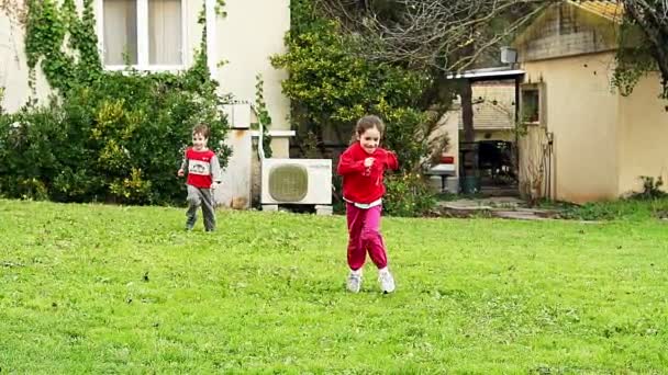 Двоє маленьких дітей біжать у повільному русі до камери — стокове відео