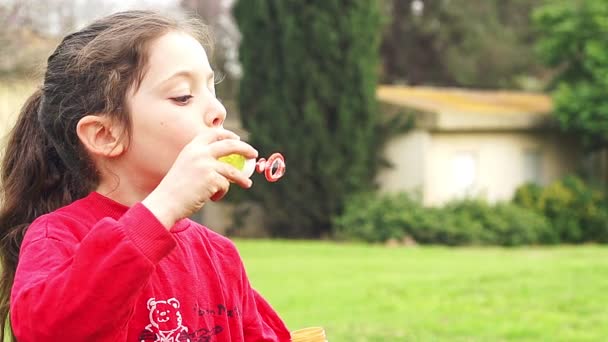 Roztomilá holčička foukání mýdlové bubliny v pomalém pohybu — Stock video