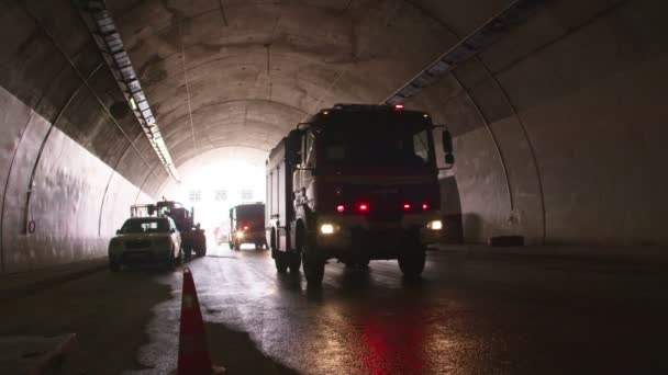 Camiones de bomberos entrando en un gran túnel con luces rojas para rescate — Vídeo de stock