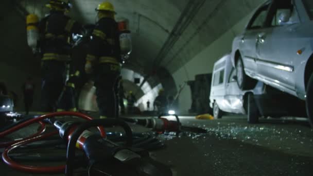 Escena de accidente de coche dentro de un túnel, bomberos rescatando a personas de los coches — Vídeo de stock