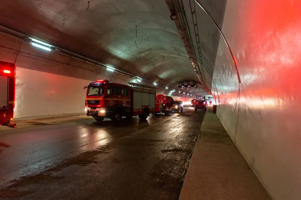 Camions de pompiers entrant dans un grand tunnel avec des feux rouges pour le sauvetage — Photo