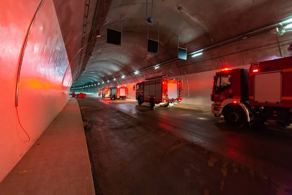 Kırmızı ışıklar ile büyük bir tünel kurtarma için giren itfaiye araçları