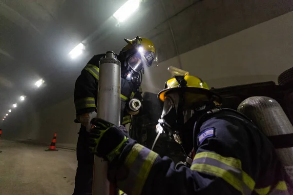 Unfallort im Tunnel: Feuerwehrleute retten Menschen aus Autos — Stockfoto