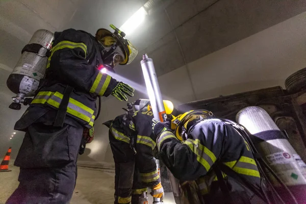 Сцена автокатастрофи всередині тунелю, пожежники рятують людей від автомобілів — стокове фото