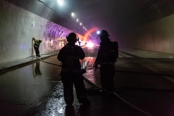 Accident de voiture dans un tunnel, pompiers secourant des gens de voitures — Photo