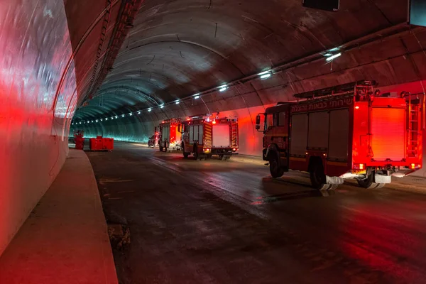 Camions de pompiers entrant dans un grand tunnel avec des feux rouges pour le sauvetage Images De Stock Libres De Droits