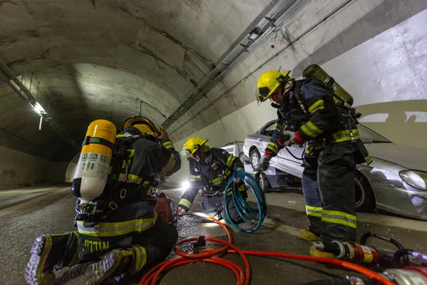 자동차 사고 현장 터널, 자동차에서 사람들을 구조 하는 소방 관 내 로열티 프리 스톡 이미지