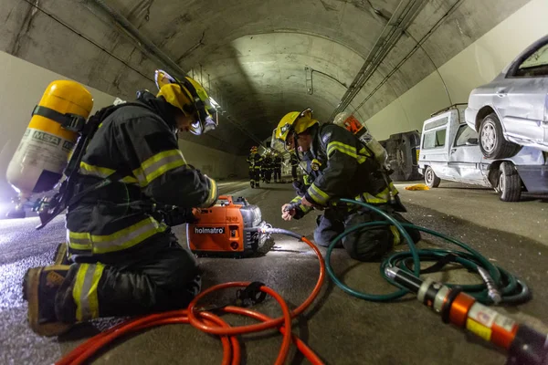 Adegan kecelakaan mobil di dalam terowongan, pemadam kebakaran menyelamatkan orang-orang dari mobil Stok Gambar Bebas Royalti