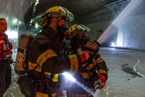 Car accident scene inside a tunnel, firefighters rescuing people from cars Stock Picture