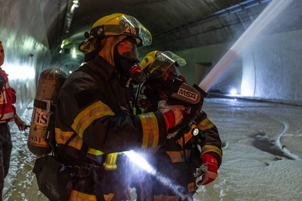 Car accident scene inside a tunnel, firefighters rescuing people from cars Stock Image