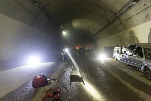Adegan kecelakaan mobil di dalam terowongan, pemadam kebakaran menyelamatkan orang-orang dari mobil Stok Foto Bebas Royalti