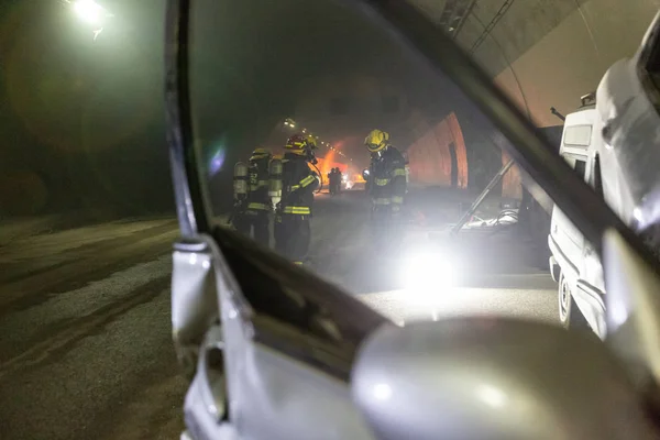 Car accident scene inside a tunnel, firefighters rescuing people from cars Stock Picture