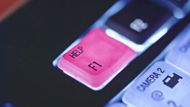 Gros plan du doigt appuyant sur le bouton d'aide rouge sur un clavier rétroéclairé — Video