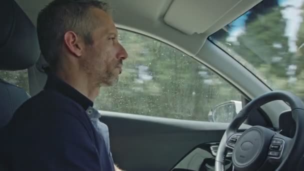 Kierowca-mężczyzna siedzi w samochodzie autonomiczne, pozwalając jazdy samochodem przez siebie — Wideo stockowe