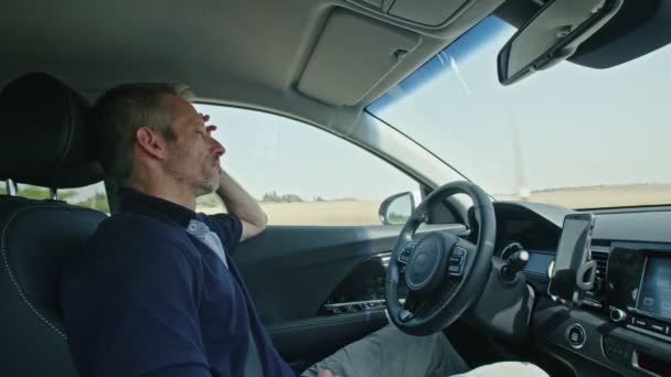 Männlicher Fahrer sitzt in einem autonomen Auto und lässt das Auto selbstständig fahren — Stockvideo