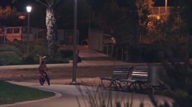 İki çocuk gece bir parkta bisiklet sürme