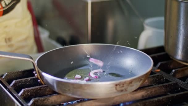 Пурпурный лук жареный на сковороде с оливковым маслом — стоковое видео