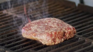 Ağır çekim bir ızgara sığır eti hamburger yakın çekim duman ve alevler