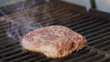 Ağır çekim bir ızgara sığır eti hamburger yakın çekim duman ve alevler