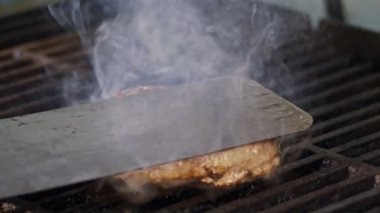 Ağır çekim bir ızgara sığır eti hamburger yakın çekim duman ve alevler