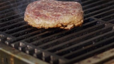 Ağır çekim bir ızgara sığır eti hamburger yakın çekim duman ve alevler