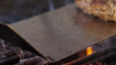 Ağır çekim bir ızgara sığır eti hamburger yakın çekim duman ve alevler