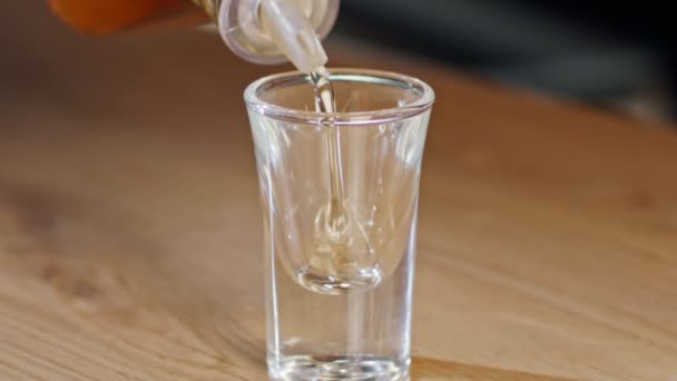 Slow motion of a whiskey shot poured into a glass — Stock Video