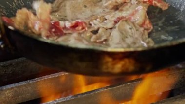 Ağır çekim alevler ile bir tavada pişmiş rosto